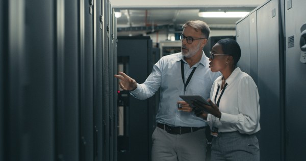 two people looking at a data center cabinet
