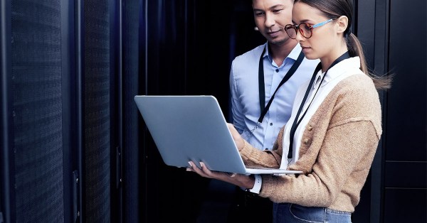 Professional IT consultants, a man and a woman in business attire, utilizing Managed Services in Colocation to optimize an IT infrastructure, exemplifying the benefits of colocation data center solutions.