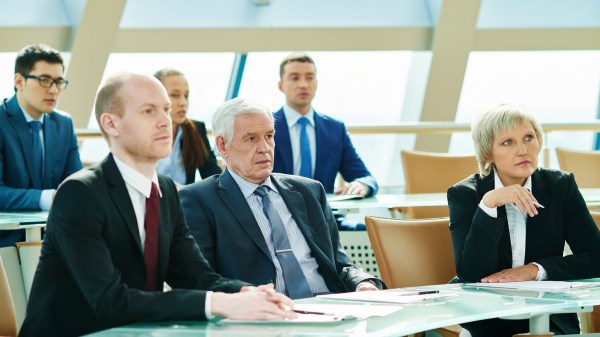 6 people in business dress watching a presentation